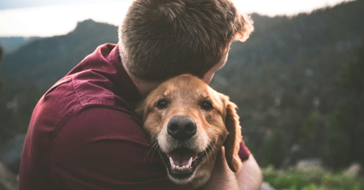 man hugging dog